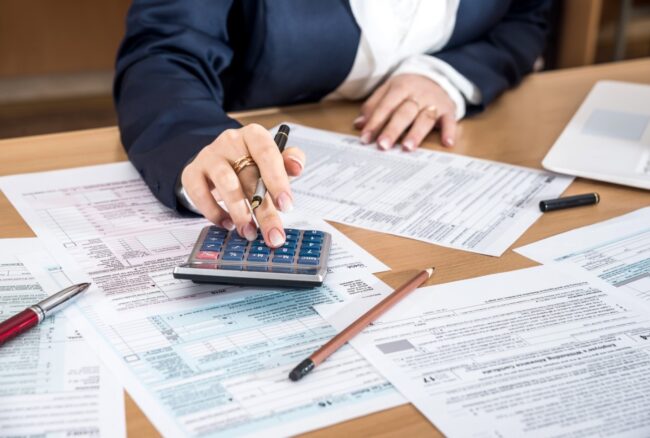 AdobeStock_192878728 Businesswoman doing taxes with a calculator | Lemasters, CPA is a specialized accounting firm in Northwest Florida providing premier business valuations, litigation support, and tax services